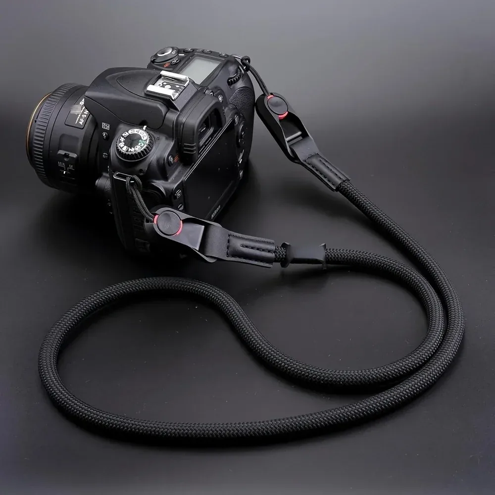 검은색 로프 스트랩이 장착된 DSLR 카메라